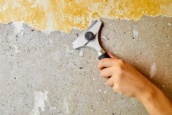 Hand Met Schraper Schilt Een Laag Gebarsten Gele Verf Betonnen — Stockfoto