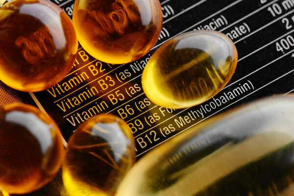 Close-up of a black label with supplements facts of a multivitamin complex, omega-3 gelatin capsules and vitamin D3, medicines