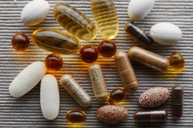 Doku arka planında diyet takviyeleri, haplar, vitaminler ve ilaçların yakın plan görüntüsü