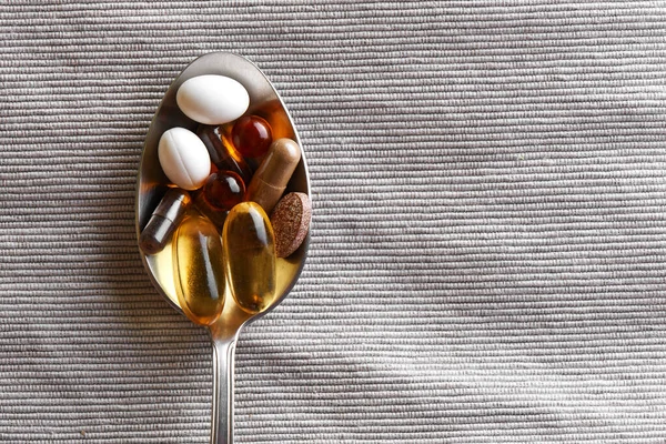 Close Tablespoon Filled Various Dietary Supplements Tablets Vitamins Gray Fabric — Stock Photo, Image