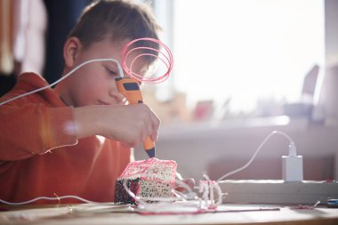 Çocuk 3D kalemle hacim plastik figürleri yapıyor. Evdeki ve okuldaki çocuklar için eğitici bir oyuncak. Çal ve çalış