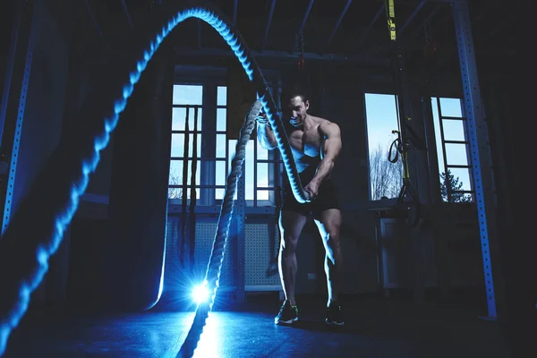 筋肉質の体を持つフィットネスマン選手は クロスフィットを行います ジムでのロープと演習 スポーツワークアウト — ストック写真