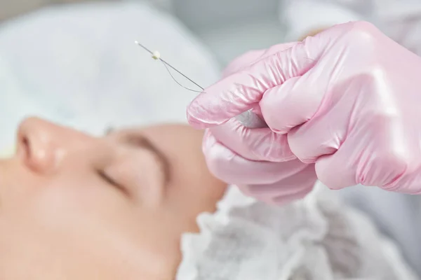 Profesyonel kozmetik uzmanının ofisinde yüz bakımı, mesolitlerle yüz gerdirme, yaşlanmayı önleyen yakın plan gençleştirme.