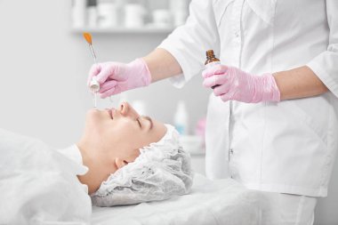 Kuafördeki profesyonel güzellik uzmanı genç bir kadın için kapsamlı yüz bakımı sağlıyor. Pore temizleme prosedürleri, tüm sezon soyma, yaşlanmayı önleyici maske