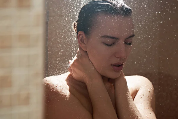 真正赤裸裸的金发姑娘洗澡 在浴室里用水滴洗性感的身体 闭着眼睛享受 — 图库照片