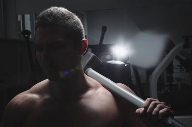 Spor salonunda kaslarını şişiren kaslı güçlü atletik adamın portresi vahşi vücut geliştirme egzersizleri, spor beslenme ve ekipman konsepti.