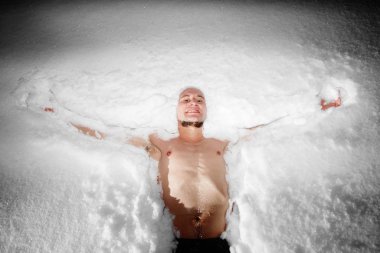 Healthy hardening. Young man dives and walks in the snow after hot sauna and bathes in cold water. Strengthening the body and spirit concept clipart