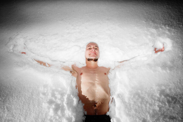 Healthy hardening. Young man dives and walks in the snow after hot sauna and bathes in cold water. Strengthening the body and spirit concept
