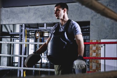 Profesyonel boks antrenörü. Ringlerde spor ekipmanları ve boksörler.