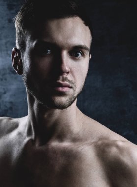 Kameraya bakan, traşsız, vahşi, beyaz adamın yakın plan sanat portresi. Kas yığını, çıplak seksi, yakışıklı model.