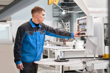 Mühendis kontrol panelindeki düğmeye basıyor. Otomatik üretim fabrikası kavramları, modern üretim teknolojileri