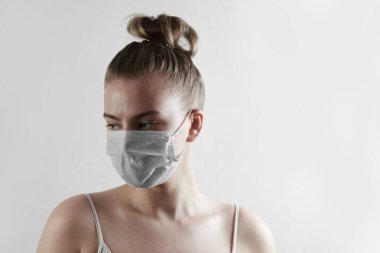Koruyucu tıbbi maske takan kadın beyaz arka planda izole edilmiş. Koronavirüse karşı koruma, toz, kentsel sis, grip, hava kirliliği