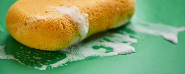 Esponja Lavado Amarillo Espuma Jabón Sobre Fondo Verde Cerca Aislado — Foto de Stock