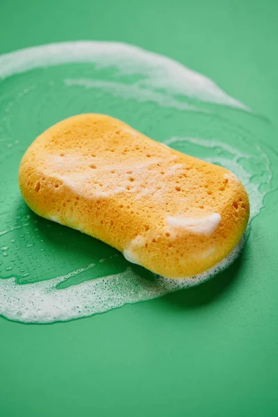 Esponja Lavado Amarillo Espuma Jabón Sobre Fondo Verde Cerca Aislado — Foto de Stock