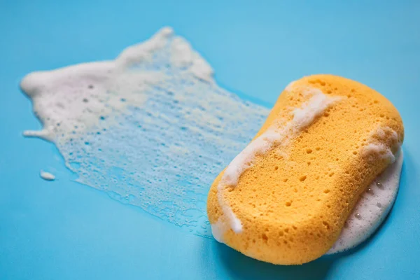 Gelber Waschschwamm Seifenschaum Auf Blauem Hintergrund Isoliert — Stockfoto