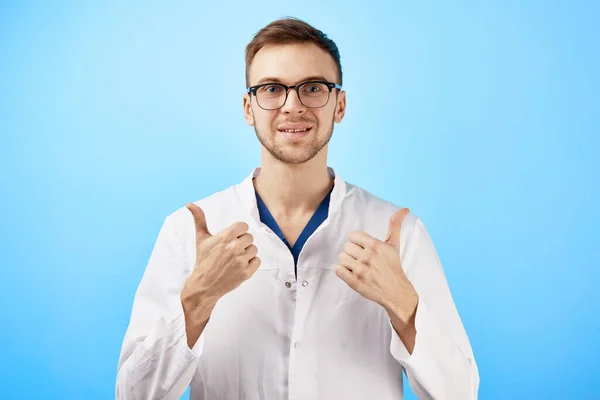 Joyful Smiling Doctor Glasses Medical Coat Shows Thumbs Isolated Blue — Stock Photo, Image