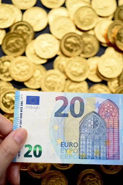 Vinte euros na mão e moedas de ouro — Fotografia de Stock
