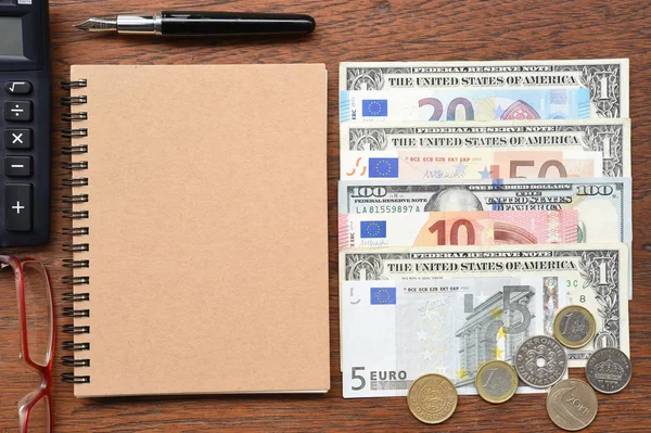 Euroscheine und Dollarscheine mit Münze, Brille und Taschenrechner — Stockfoto