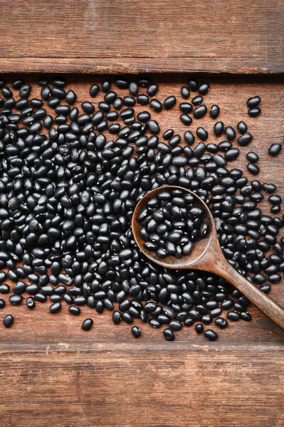 Black beans on wooden background