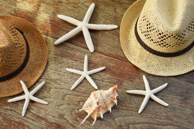 Yaz hasır şapka ve denizyıldızı ahşap arka plan üzerinde