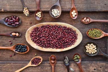 Meşe ağacından arka planda tahtadan kaşık içinde fasulye ve mercimek çeşitleri.