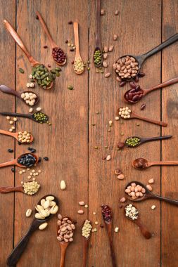 Meşe ağacından arka planda tahtadan kaşık içinde fasulye ve mercimek çeşitleri.