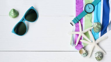 Güneş gözlüğü ve beyaz ahşap arka planda kol saati olan bikiniyi kapat.