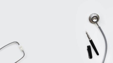 Beyaz arkaplanda izole edilmiş kalemle steteskopu kapat