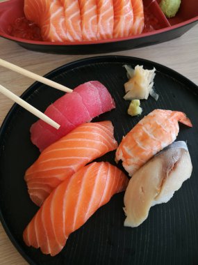 Seramik tabakta taze suşi ve Japon yemeği.