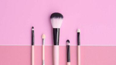 Pembe arka planda makyaj fırçaları                               