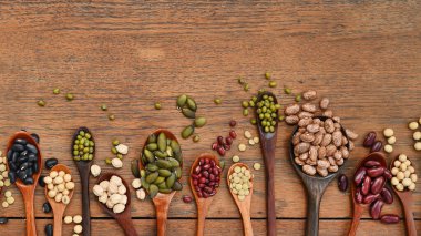 Meşe ağacından arka planda tahtadan kaşık içinde fasulye ve mercimek çeşitleri.