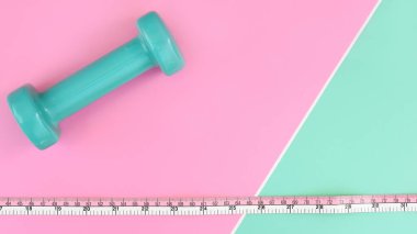 Spor konsepti dambıl ve mezura pembe ve yeşil arka planda