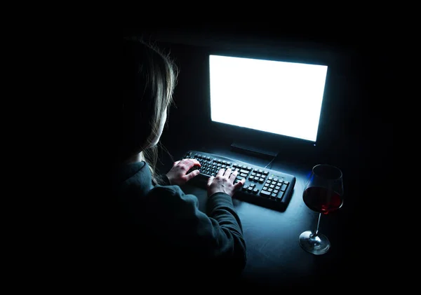 Silhouette di donna che digita a computer in buio illuminato da schermo — Foto Stock
