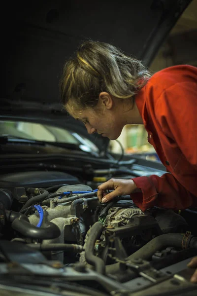 Female mechanic inspecting car engine — Stock Photo, Image