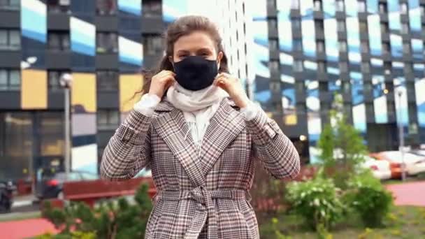 Jovem bela menina caucasiana tirar uma máscara preta sorriso respiração durante uma pandemia — Vídeo de Stock