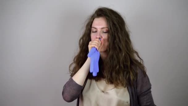 Schöne brünette junge Frau bläst ihren Handschuh auf und lacht — Stockvideo