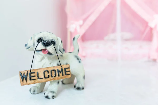 Mooie pup pop houdt een "Welkom" teken panel thuis. — Stockfoto