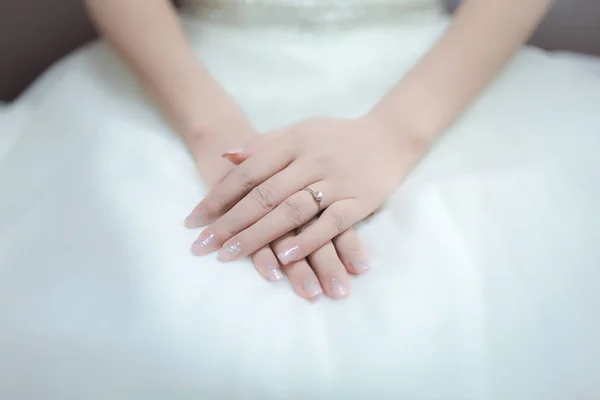 Gelinin güzel elleri geçiş ve onun kucağına yalan. Bu hassas güzel manikür parmakları var. Nikah yüzüğü parmağına giyiyor. -Yumuşak odak