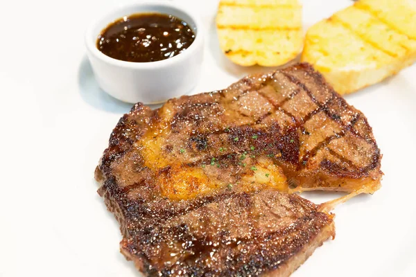 Izgara Dana biftek - ızgara domuz fileto biftek, hizmet sarımsaklı ekmek ve beyaz tabak içinde Tay baharatlı sos ile. -Kapat