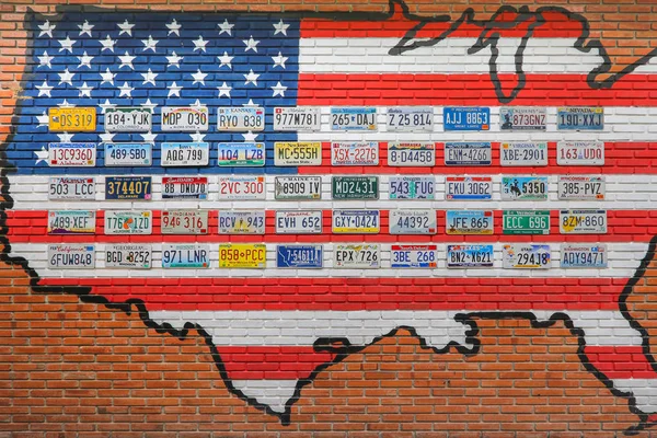 Ratchaburi, Thailand - December  15, 2016: Various old American license plates from different states on the wall of brick building in Thailand.