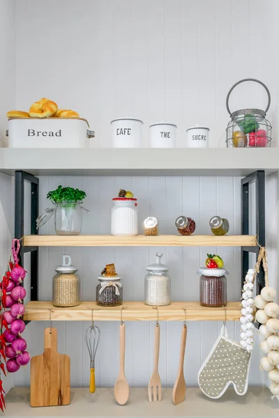 Kitchen shelves with various food ingredients and utensils.