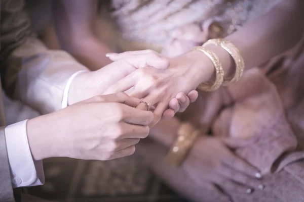 Groom slipping ring on finger of bride in wedding ceremony. — Stock Photo, Image