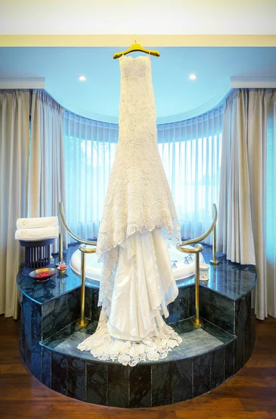 Весільна сукня, що висить на стелі в розкішній кімнаті . — стокове фото