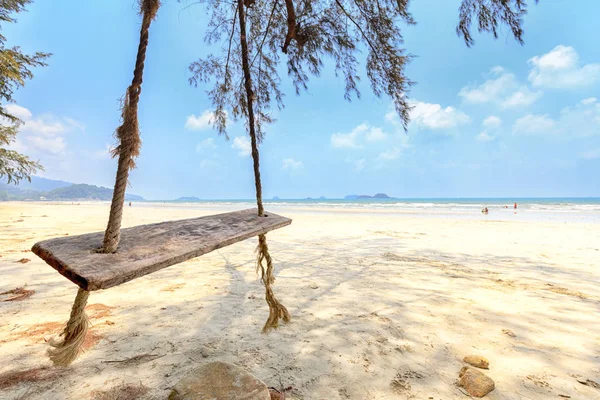Columpio de madera colgando de un árbol en la playa tropical. - enfoque selectivo — Foto de Stock