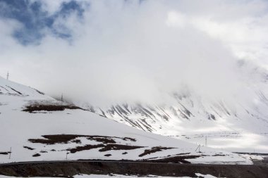 Dağ manzarası, bulutlar kar yamaçları üzerinde