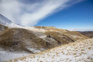 Kış manzarası. Güzel dağlarda kar, beyaz bulutlar pitoresk gorge üzerinde mavi gökyüzünde. Kuzey Kafkasya Priprda
