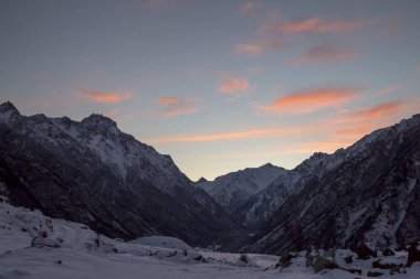 Manzara, turuncu bulutlar gökyüzünde kar tepelerde üzerinde Kuzey Kafkasya doğası akşam