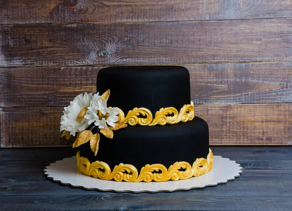 Ouro do casamento e bolo preto e cupcakes em invólucros de renda — Fotografia de Stock