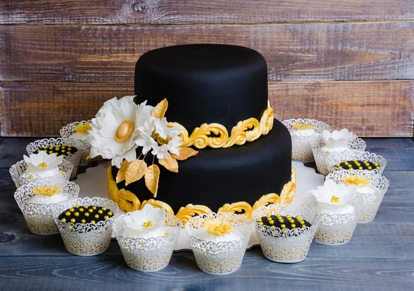 Oro de la boda y pastel negro y cupcakes en encaje envolturas —  Fotos de Stock