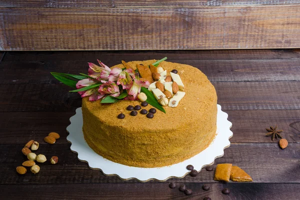 Délicieux gâteau au miel avec des fleurs et des noix — Photo